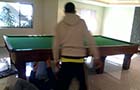 Proficient removalists expertly managing the movement of a pool table with precision